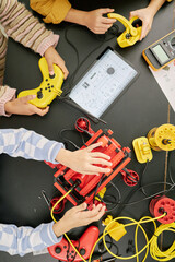 Group of students collaborating on an educational tech project, using various gadgets and tools for...