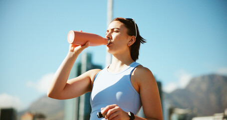 Fitness, sports and woman drinking water in city on break, relax or exercise recovery. Workout,...