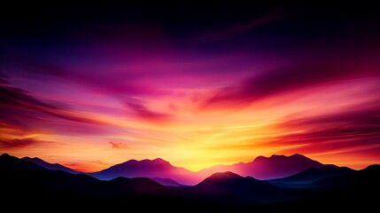 Obraz premium Mountain silhouettes are visible against a vibrant sunset sky with hues of orange, pink, and purple clouds.