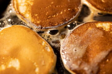 pancakes with butter in a pan, hot metal pan while cooking pancakes with butter, close up