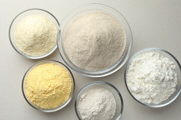 Different types of flour on white background, flat lay