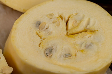 sliced long white squash with a hard peel, ripe squash on the kitchen table during cooking and slicing
