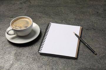 Notebook, pen and coffee on grey table, closeup