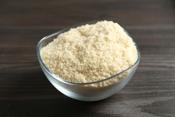 Flour in bowl on dark wooden table, closeup