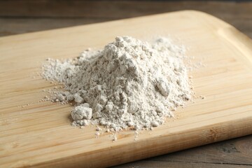 Pile of flour on wooden table, closeup