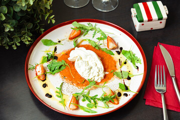 Burrata cheese with arugula and strawberries.