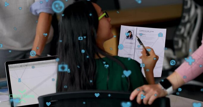 Candidate holding CV and pointing pen at business office desk, displaying digital heart icon