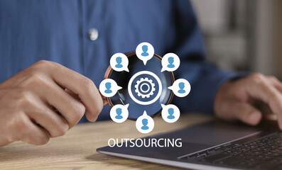 Outsourcing concept. Human resources and global recruitment for business. Person use laptop with outsourcing icon on virtual screen.