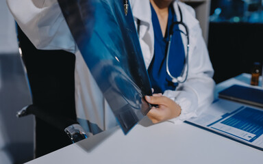 The doctor explain the old lady in retired life patient on lungs x-ray film and discuss treatment...