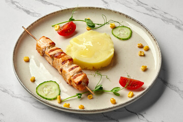Grilled salmon skewer with mashed potatoes and vegetables on elegant plate