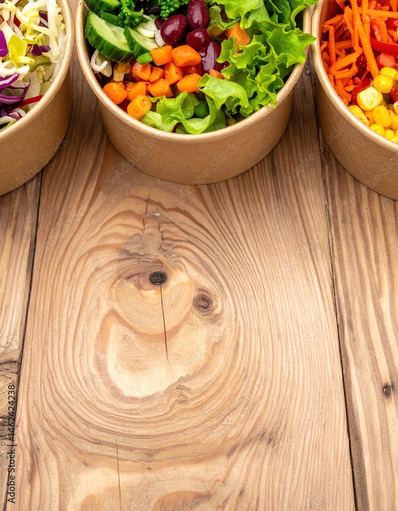 Poster a rustic wooden table displays an array of bowls in various sizes and styles, showcasing vibrant col