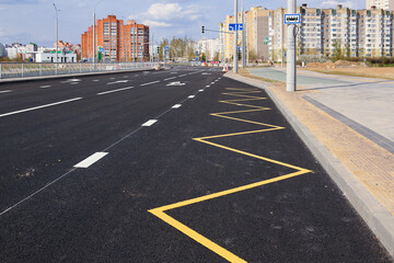 Bus stop sign with yellow paint on asphalt