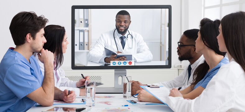 Medical Video Conference. Team Of Doctors Having Virtual Meeting, Looking At Screen Communicating With Remote African American Male Colleague Sitting In Modern Clinic Office. Panorama, Collage - Powered by Adobe