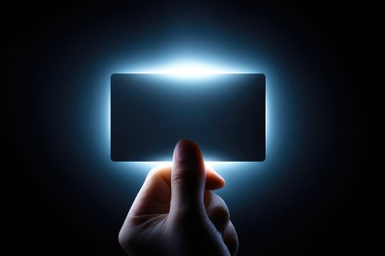 Illuminated blank rectangle held by a hand.