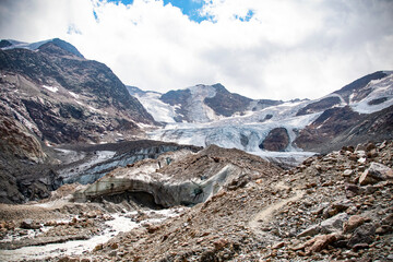 Snowy alpine peak with glacier and cloudy sky