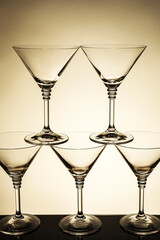 Many empty clean glasses on mirror surface against beige background