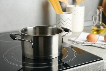 Plakat Cooking pot on cooktop indoors. Kitchen utensil