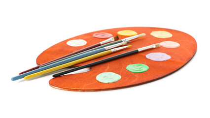 Wooden palette with paints and brushes isolated on white