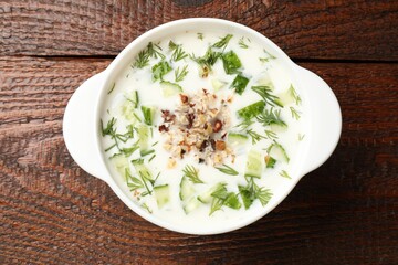 Fresh tasty cucumber soup on wooden table, top view