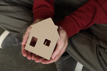 Homeless man with carton house figure outdoors, above view