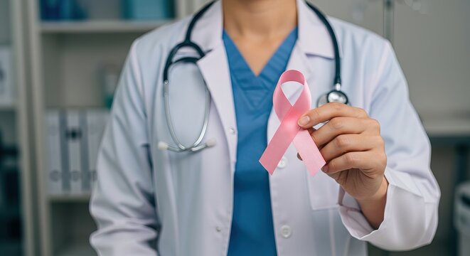 Doctor holding a pink ribbon for breast cancer awareness