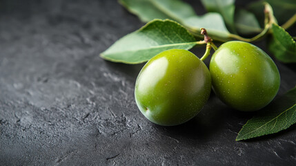 A vivid green plum displayed on a dark gray backdrop