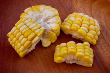 Fresh Corn on the Cob Sliced and placed on a wooden cutting board, ready for cooking.