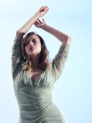 Naklejka premium Girl model in green dress on blue studio background.