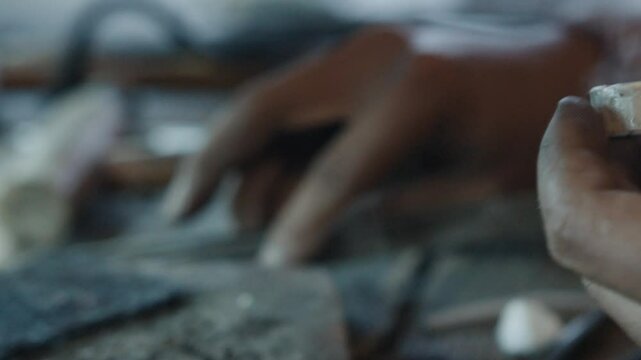 Jeweler shaping silver ring with hammer and tools