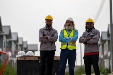 Structural engineer and worker working with blueprints discuss at the construction site. Engineers on building site. Two worker or labor and one engineer are reviewing the project. Architecture.
