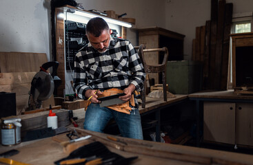 Portait of carpenter in his workshop using tablet.