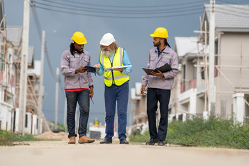 Fototapeta premium Structural engineer and worker working with blueprints discuss at the construction site. Engineers on building site. Two worker or labor and one engineer are reviewing the project. Architecture.