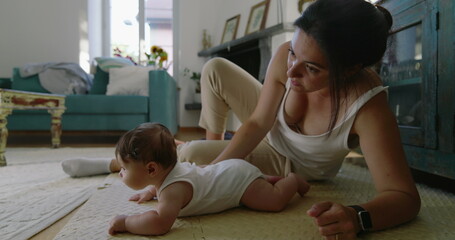 Mother and baby spending time together on the floor in a bright and inviting living room, capturing...