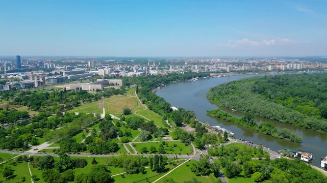 Aerial view of Belgrade where the Sava and Danube rivers meet. Visible landmarks include Kalemegdan Fortress (Beogradska tvrđava), city bridges, and U&scaron;će Park &mdash; a perfect urban-meets-nature panorama