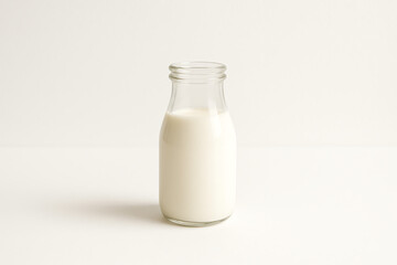 A glass bottle filled with fresh, white milk, set against a simple white background. The image showcases the pure essence of dairy in a clean and minimalistic style.