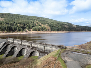 drone footage of Loch Tarsan freshwater loch and impounding reservoir water supply near Dunoon Scotland. manmade concrete structure in wild nature feeds Striven Hydro-Electric Scheme 
