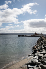 view down coastline to Victorian Dunoon timber ferry pier in Scotland, Category A listed wooden structure in Firth of Clyde closed to public needs renovation. 