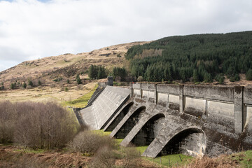 drone footage of Loch Tarsan freshwater loch and impounding reservoir water supply near Dunoon Scotland. manmade concrete structure in wild nature feeds Striven Hydro-Electric Scheme 