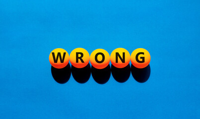Wrong symbol. Concept word Wrong on beautiful yellow tennis ping pong balls. Beautiful wooden table...