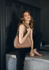 Fototapeta premium Girl model in the interior in stylish clothes with a bag. style fashion.