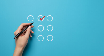 Hand marking a checklist with a red check mark on a blue background with empty circles grid design real estate business ,technology ,selling ,purchasing ,agreement