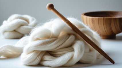 Soft, white wool in a heap with a wooden spindle and bowl
