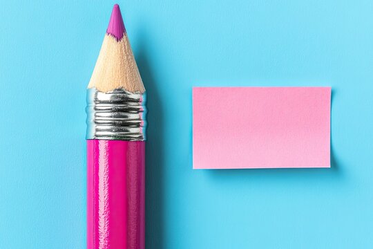Magenta pencil and pink sticky note on a light blue background.  A sharpened magenta pencil and a rectangular pink sticky note rest on a light blue surface. The pencil's tip is a vibrant purple