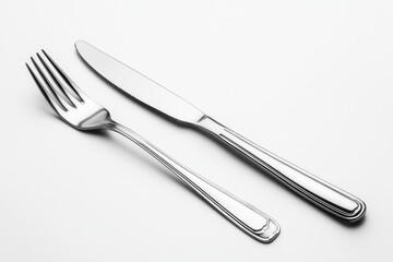 Knife and fork on white surface with crumbs.
