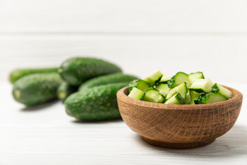 Cucumber on wooden background. Slice of cucumber on background. Fresh organic green cucumbers gherkin. Vegan. Salad ingredient. Farm vegetables. Cut vegetables with knife. Space for text. Copy space