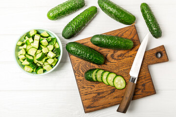 Cucumber on wooden background. Slice of cucumber on background. Fresh organic green cucumbers gherkin. Vegan. Salad ingredient. Farm vegetables. Cut vegetables with knife. Space for text. Copy space
