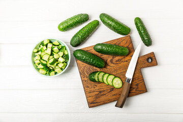 Cucumber on wooden background. Slice of cucumber on background. Fresh organic green cucumbers gherkin. Vegan. Salad ingredient. Farm vegetables. Cut vegetables with knife. Space for text. Copy space