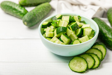 Cucumber on wooden background. Slice of cucumber on background. Fresh organic green cucumbers gherkin. Vegan. Salad ingredient. Farm vegetables. Cut vegetables with knife. Space for text. Copy space