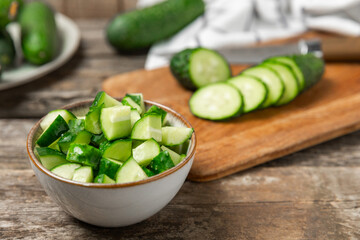 Cucumber on wooden background. Slice of cucumber on background. Fresh organic green cucumbers gherkin. Vegan. Salad ingredient. Farm vegetables. Cut vegetables with knife. Space for text. Copy space