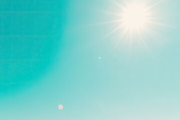 Bright sun shining on a pale teal sky.  Soft light,  with a few scattered clouds